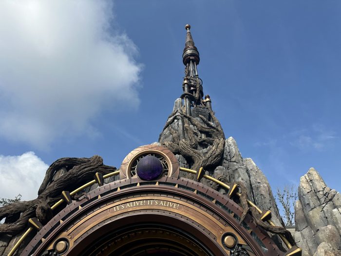 A closer look at the vine-wrapped spire crowning the steampunk archway that marks the land's entrance.