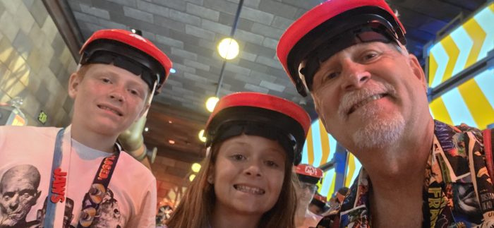 Three of us grinning for a quick photo before the ride, caps and headsets on.