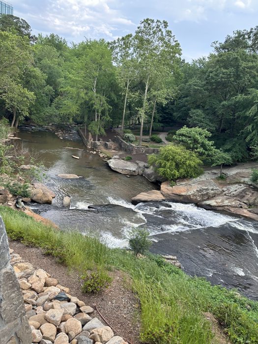 The river tumbling over wide rocky falls in the heart of the park.