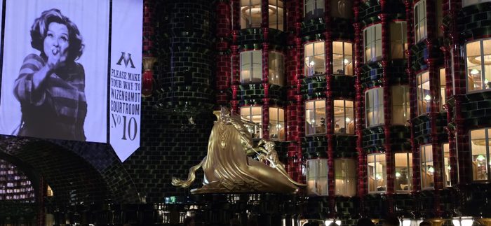 Golden statues and glowing courtroom banners tower over the winding queue.