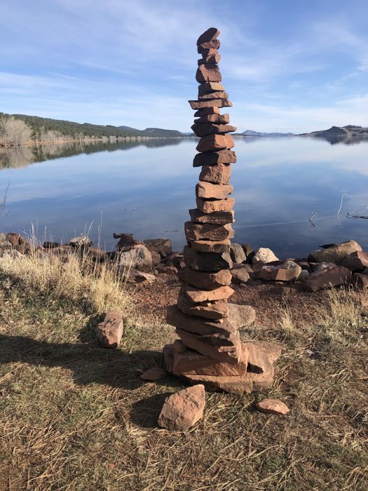 A quiet morning cairn mirrored in glassy Carter Lake.