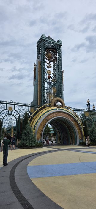 An ornate clockwork archway, topped with a spinning brass orrery, marks the path into another corner of the park.