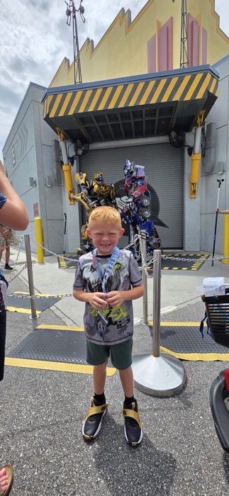 Another pose with the towering robot guardians looming behind him.