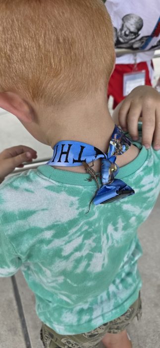 The same curious lizard clings to the lanyard knot for a ride down someone's back.